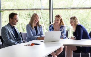 Our HR Story and Brand Promise Employees sat at a desk looking at a laptop