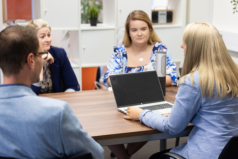 Employees sat around a desk